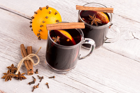 two glasses of mulled wine with orange and spicesの写真素材