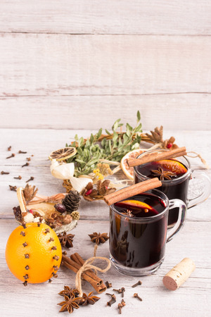 two glasses of mulled wine with orange,anise, cinnamon and christmas decorationの写真素材