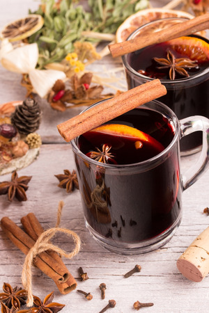 mulled wine glasses with spices, orange and christmas decorationの写真素材