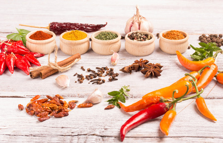 various spices in cute wooden bowls on a wooden tableの写真素材