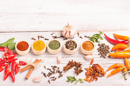 Various spices and herbs on white wooden background.の写真素材