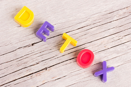 the word detox written on a white wooden surfaceの写真素材