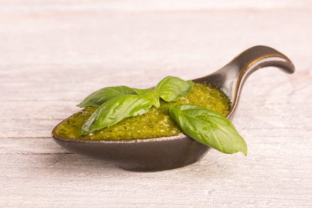 basil pesto in ceramic bowl on kitchen tableの写真素材