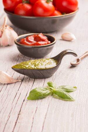 pesto and tomato sauce on white wooden tableの写真素材