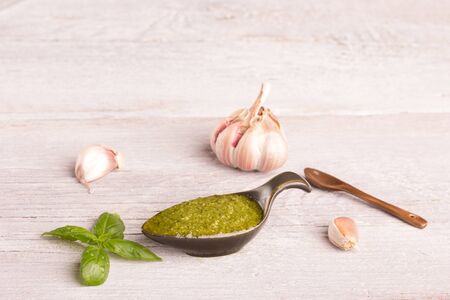 pesto sauce in a cute little bowl over white wooden backgroundの写真素材