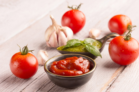 tomato and pesto sauce with basil and tomato on white wooden tableの写真素材