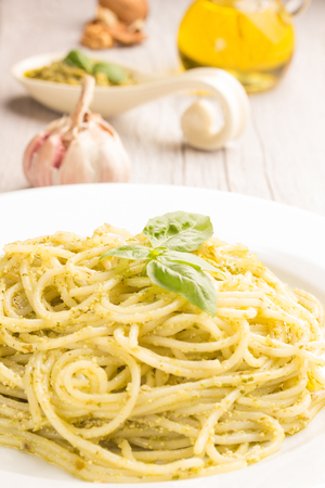 Close-up of spaghetti with basil pesto on white wooden tableの写真素材