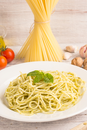 spaghetti with green pesto sauce with ingredientsの写真素材