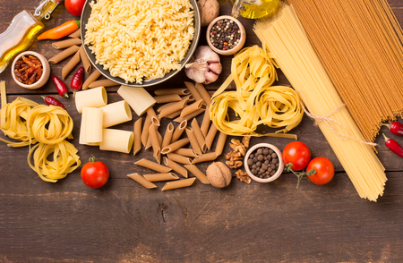 various italian pasta with ingredients on wooden tableの写真素材