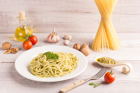 spaghetti with green pesto sauce with ingredientsの写真素材