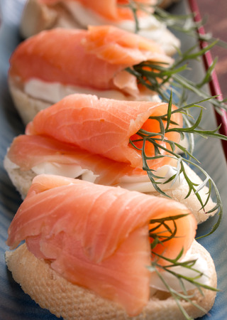 sandwiches with smoked salmon and cream cheese on plateの写真素材