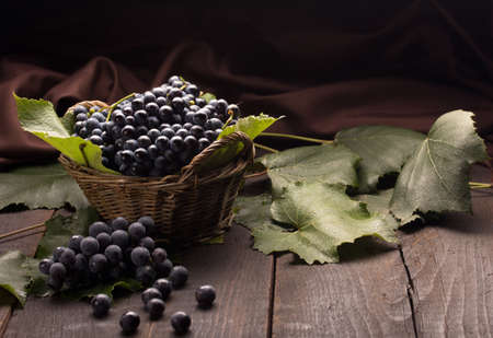 grapes in a cute basket on a wooden tableの写真素材
