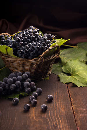 grapes in a cute basket on a wooden tableの写真素材