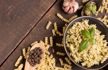 fusilli with pesto sauce over wooden backgroundの写真素材