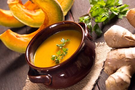 pumpkin soup in a cute rustic bowl  on a wooden tableの写真素材