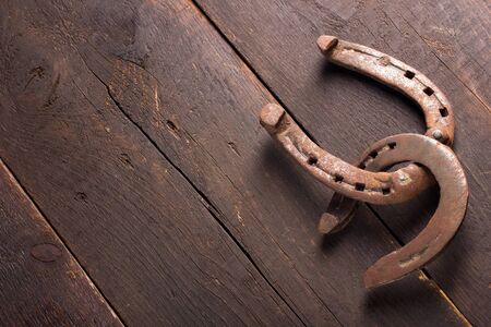 Two horseshoes on wooden boardの写真素材
