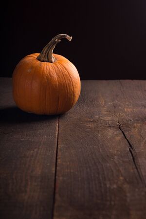 one single pumpkin on a rustic wooden tableの写真素材