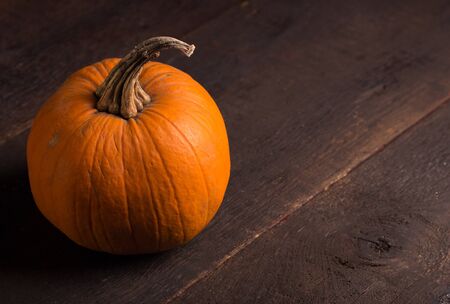 one single pumpkin over wooden tableの写真素材