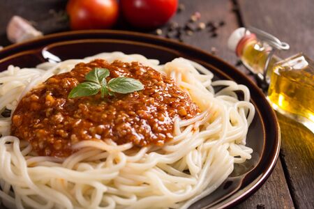 spaghetti bolognese with ingredients on wooden tableの写真素材