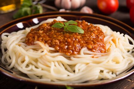 spaghetti bolognese with ingredients in the backgroundの写真素材