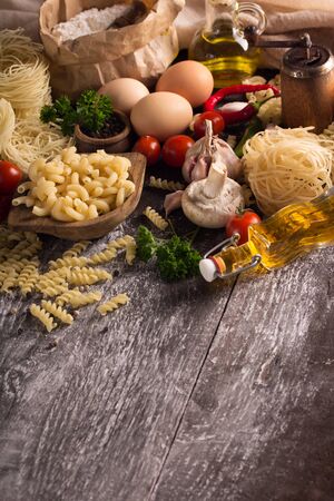 pasta and vegetables on wooden tableの写真素材