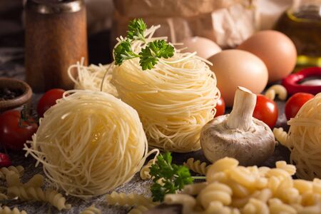 nest pasta and fussilli with herbs and vegetablesの写真素材