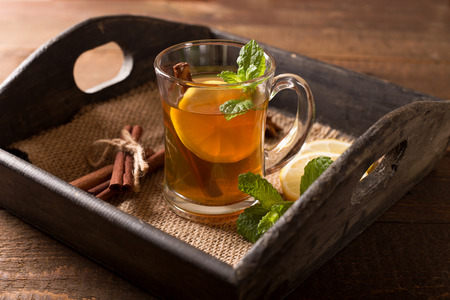 transparent glass of hot tea with lemon,mint and cinnamonの写真素材