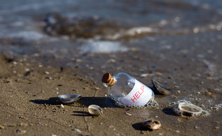 Bottle with a message for help. Sea beach.の写真素材