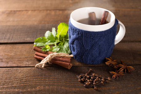 Cup of hot drink with knitted thing on.の写真素材