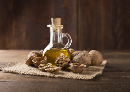 Walnut oil and nuts on wooden tableの写真素材