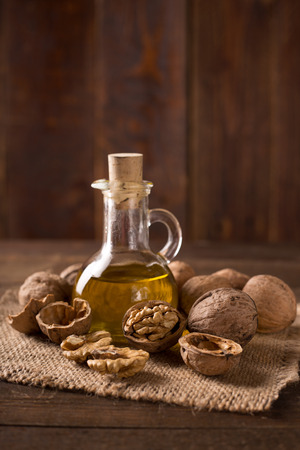 Walnut oil and nuts on wooden tableの写真素材