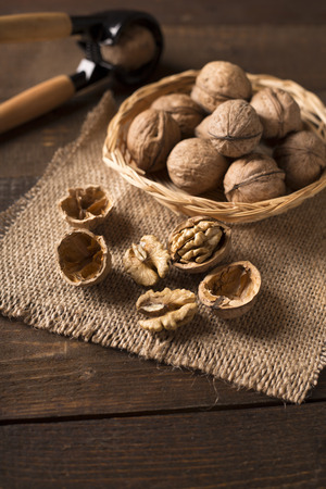 walnuts in a basket and nutcracker in the backgroundの写真素材