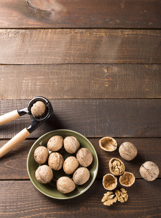 top view of walnuts on a green plate with nutcrackerの写真素材