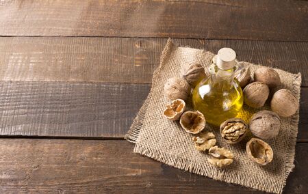 top view of walnut oil and nuts on wooden tableの写真素材