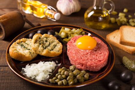 Beef tartar with capers and fresh onions on dark backgroundの写真素材