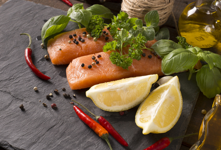 Delicious portion of fresh salmon fillet with aromatic herbs, spices and vegetablesの写真素材