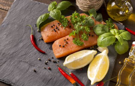 top view of raw salmon filet with herbs and spicesの写真素材