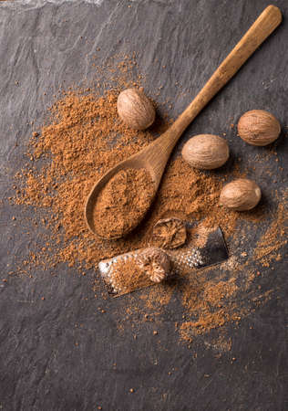 fresh grated nutmegs and whole ones over black backgroundの写真素材