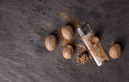 fresh grated nutmegs and whole ones over black backgroundの写真素材