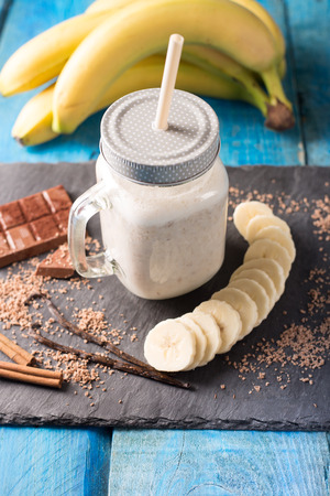 Smoothie drink with banana on aqua background. Selective focus, vertical.の写真素材