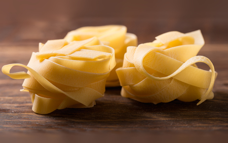 pasta tagliatelle on wooden background の写真素材