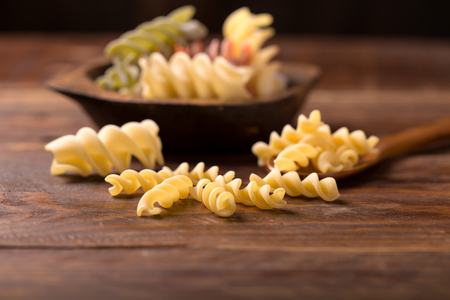 Various mix of pasta on wooden rustic background; Diet and food concept. Colored natural pasta. Spinach, beetroot, eggの写真素材