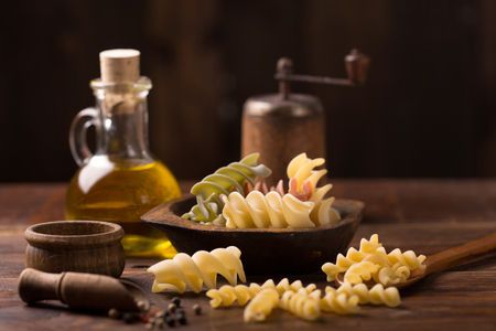 Various mix of pasta on wooden rustic background; Diet and food concept. Colored natural pasta. Spinach, beetroot, eggの写真素材