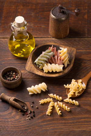 Various mix of pasta on wooden rustic background; Diet and food concept. Colored natural pasta. Spinach, beetroot, eggの写真素材