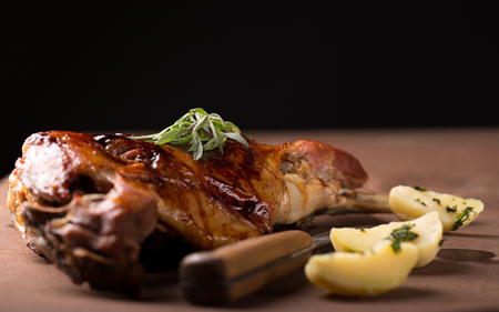 Roasted lamb leg on wooden tableの写真素材