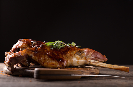 Roasted lamb leg on wooden tableの写真素材