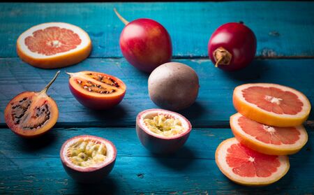closeup of passion fruit and tamarillo on wooden tableの写真素材