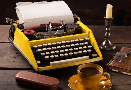 vintage typewriter,cup of coffee,book,eyeglass over vintage wooden tableの写真素材