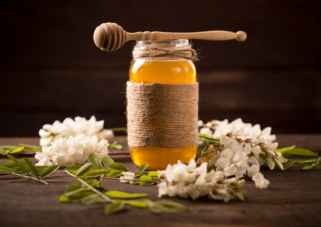 Acacia honey and flowering acacia on wooden tableの写真素材