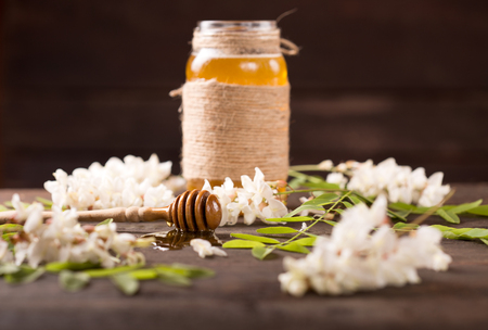 Acacia honey and flowering acacia on wooden tableの写真素材